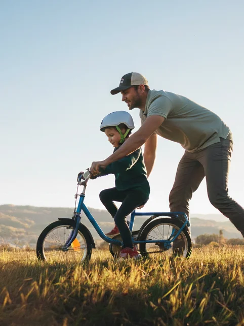 Father teaching child to ride a bike